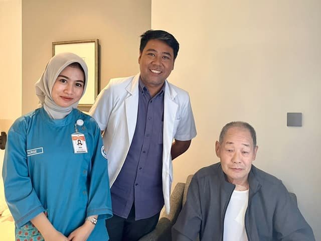 A Mitra 911 doctor and nurse with a guest after a room visit at their hotel in Yogyakarta